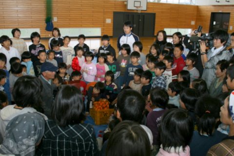 写真:北澤久敏さんの周りに集まる寺津小学校児童