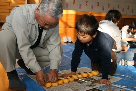 写真:吊るし方を教わる寺津小学校児童
