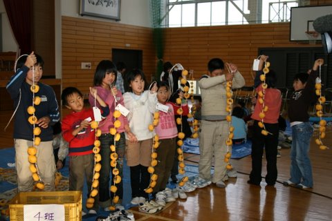 写真:できた柿を見せる寺津小学校児童