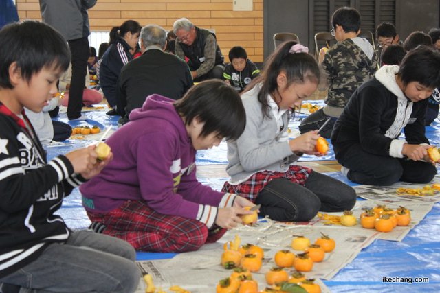 写真：柿の皮をむく児童たち（寺津地域づくり委員会）