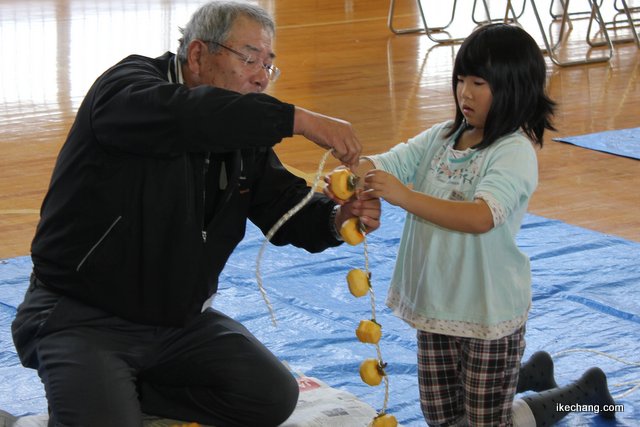 写真：柿の吊るし方を教える地域のかた（寺津地域づくり委員会）
