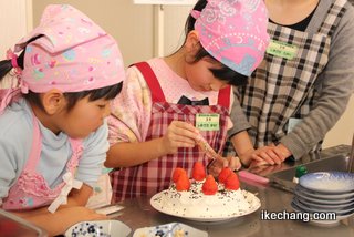 写真：ケーキにトッピングする子ども