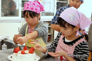 写真：ケーキにトッピングする子どもたち