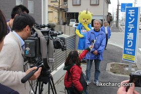 写真：インタビュー受ける柴崎会長（モンテ通り看板）