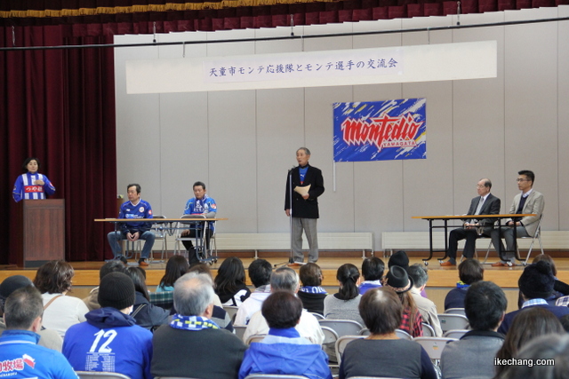 写真:ステージ上で主催者あいさつする柴崎会長(天童市モンテ応援隊交流会)