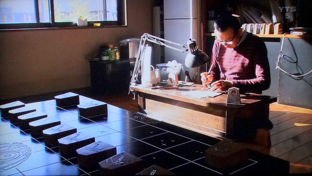 写真：スター・ウォーズ将棋駒を彫る高橋稚山さん（YTSニュースより）