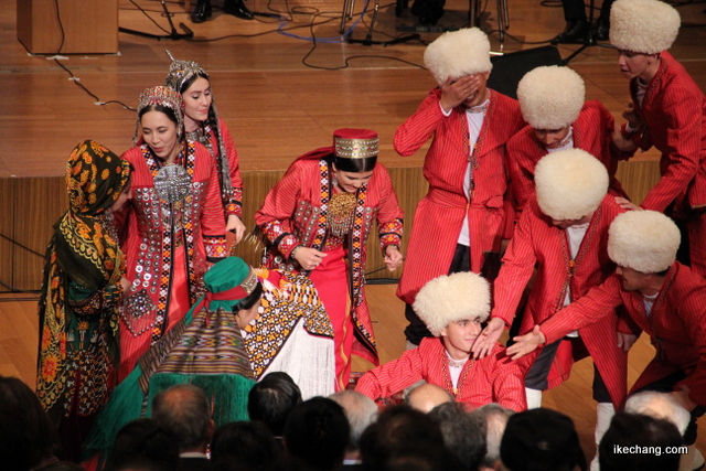 写真：フードで隠された花嫁に面と向かう花婿とその取り巻き（トルクメニスタン国との文化交流のつどい）