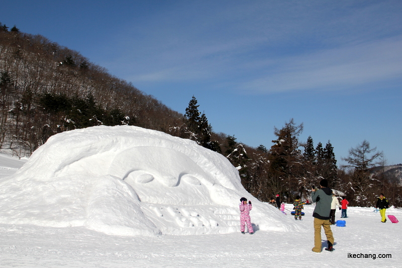 画像：天ギンちゃんの大型雪像で写真を撮る親子