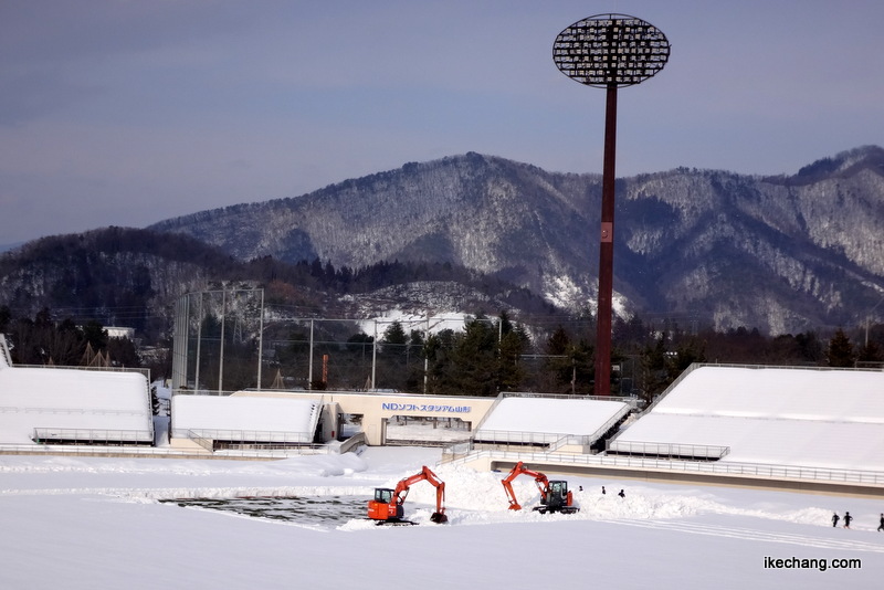 写真：ピッチの雪はバックホウで除雪