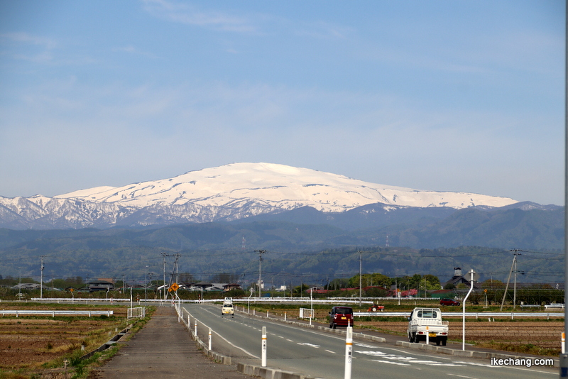 写真：霊峰月山と田起こしするトラクター