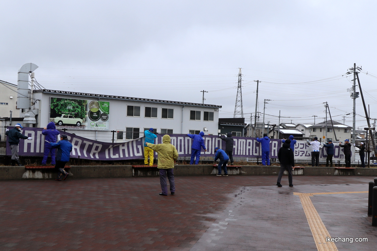 写真：横断幕を設置する天童市モンテ応援隊の参加者たち